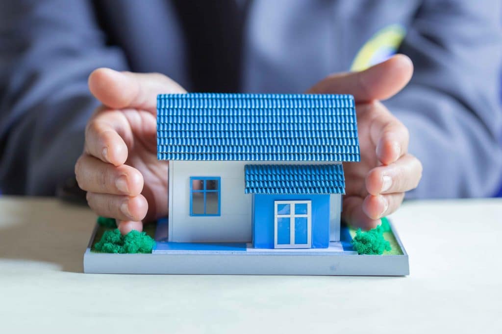 A person holding a toy house in their hands.