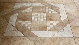 A tile floor with some brown and white tiles