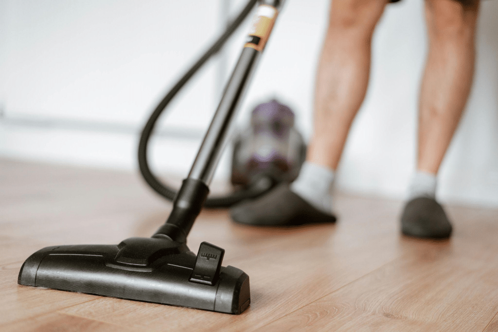 Person vacuuming a wood floor