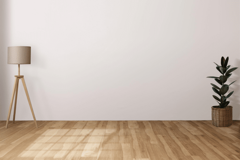 Hardwood floor in a room with a standing lamp and white walls